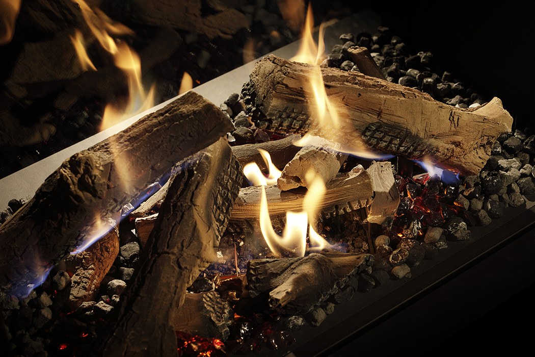 Detaliu cu bușteni ceramici maro și flăcări la arzătorul Dynamic Flame Burner al DRU Maestro 75 Tall Eco Wave