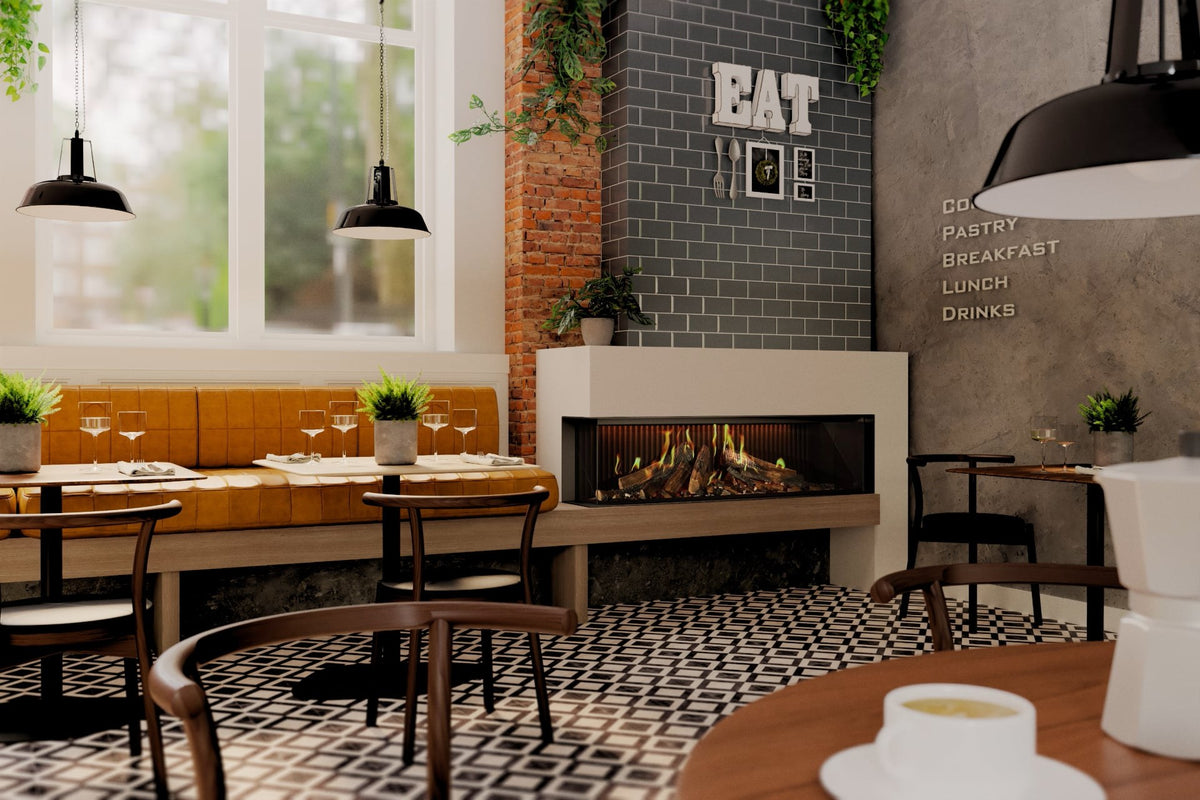 Șemineu electric DRU Virtuo 150/2 Evolve, varianta stânga (geamul lateral în stânga), într-o cutie albă pe o bancă de lemn, într-o cafenea cu perete de cărămidă